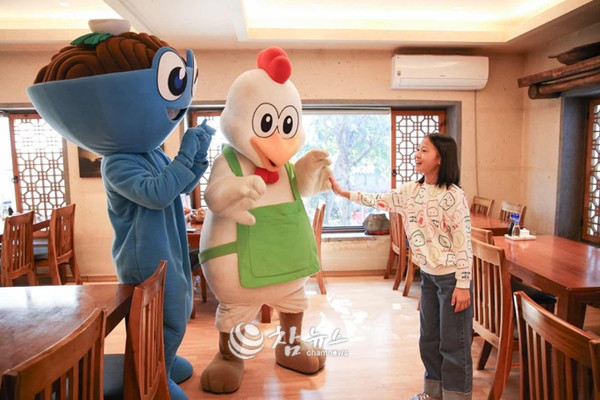 지난해 10월 16~19일 나흘간 열린 2025 춘천막국수닭갈비축제에서 한 여학생이 식당에서 축제 공식 마스코트와 인사를 나누고 있다. (사진=춘천시청 제공)